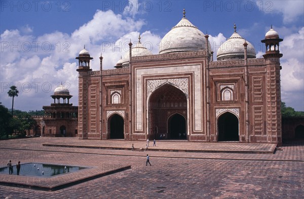 INDIA, Uttar Pradesh, Agra, "Red sandstone gateway in interior forecourt of Taj Mahal decorated with semi-precious stone inlay, carvings, and geometric pattern.  Roof domes and corner towers."