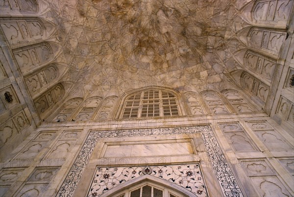 INDIA, Uttar Pradesh, Agra, Taj Mahal built 1631-1653.  Interior detail of marble walls and ceiling inlaid with semi-precious stones using process known as pietra dura and arabic script.