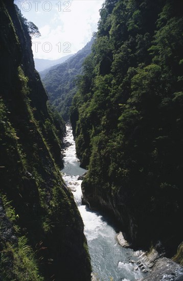TAIWAN, Near Tien-hsiang, Deep gorge with fast flowing river at the bottom of the steep cliffs covered with greenery