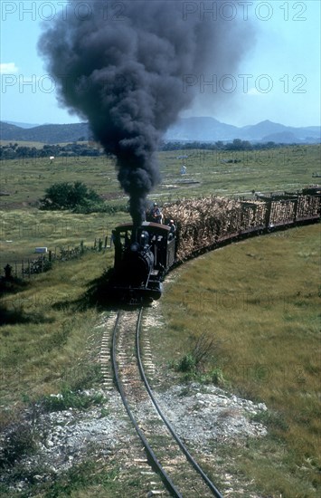 CUBA,  , Holguin, Train transporting sugar cane with plumes of black smoke pouring from the engine