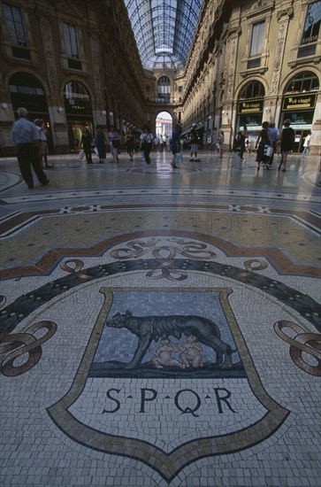ITALY, Lombardy, Milan, Galleria Vittorio Emanuele II shopping arcade interior with glass domed roof and mosaic floor lined with designer shops.