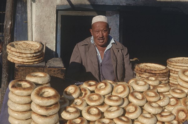 CHINA, Xinjiang, Kashgar, Baker selling bread from a street stall