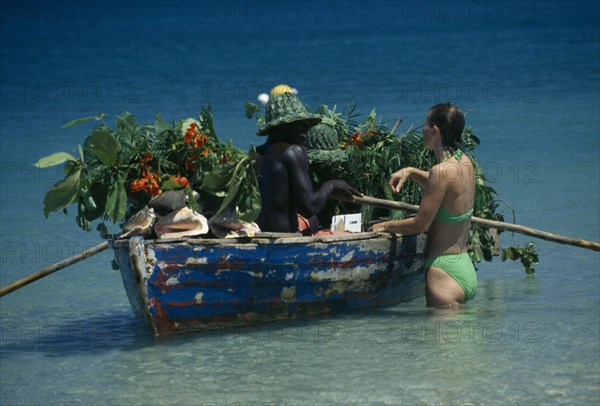 WEST INDIES, St Lucia, Reduit Beach, Beach vendor selling fruit from boat