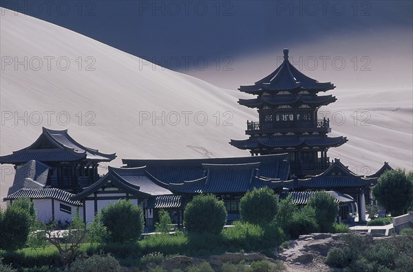 CHINA, Gansu, Dunhuang, Silk Route with a Buddhist Temple and sand dunes beyond