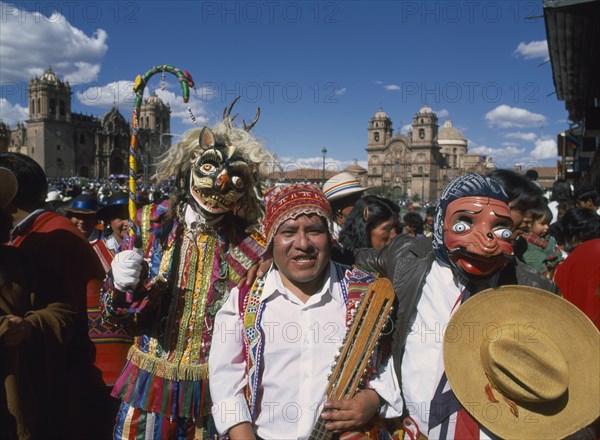 PERU, Cusco Department, Cusco, "Group of musicians and masked dancers in traditional costume at Inti Raymi.  Three quarter view, facing the camera."