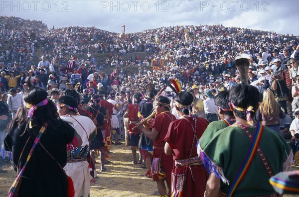 PERU, Cusco, Parade of musicians at Inti Raymi watched by crowds on the surrounding hillside.  Cuzco