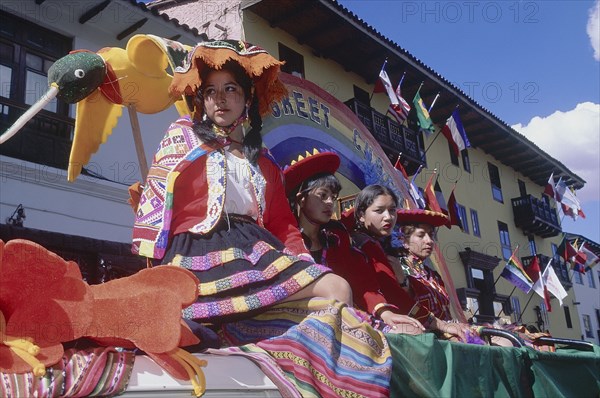 PERU, Cusco Department, Cusco, Women in tradtional costume on a processional float during Inti Raymi.