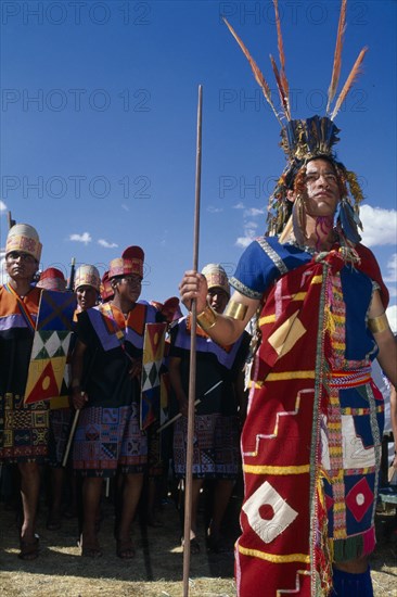 PERU, Cusco Department, Cusco, Male figure in traditional costume and feathered headress at Inti Raymi.