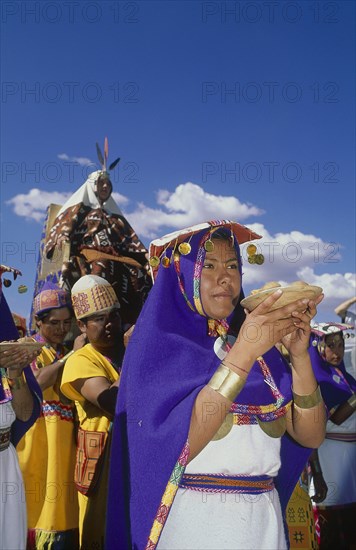 PERU, Cusco Department, Cusco, The wife of the Emperor Pachacuti being carried in her throne at Inti Raymi.   Women with offerings of food in the foreground.