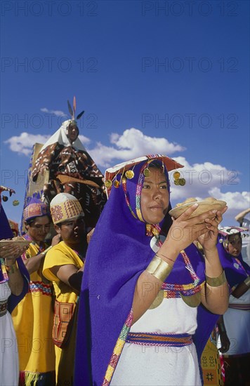 PERU, Cusco Department, Cusco, The wife of the Emperor Pachacuti being carried in her throne at Inti Raymi. Women with offerings of food in the foreground.