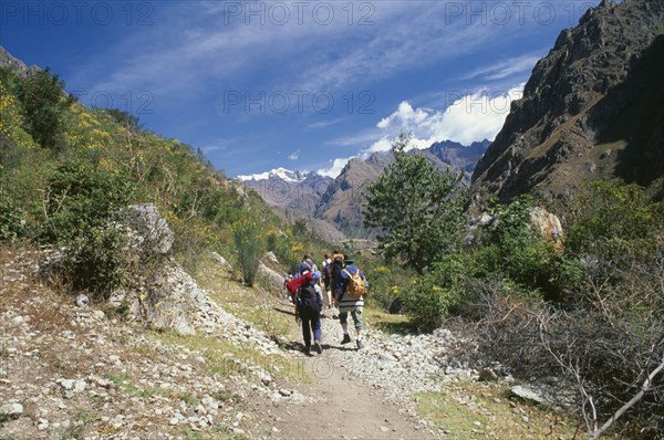 PERU, Cusco Department, The Inca Trail, Treckers with backpacks walking up a narrow mountain path.