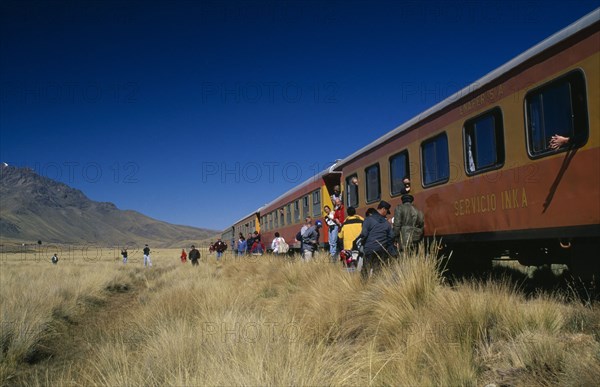 PERU, Puno Administrative Department, La Raya, Train stopped on the altiplano at the highest pass on the line between Puno to Cusco.  People disembarking.