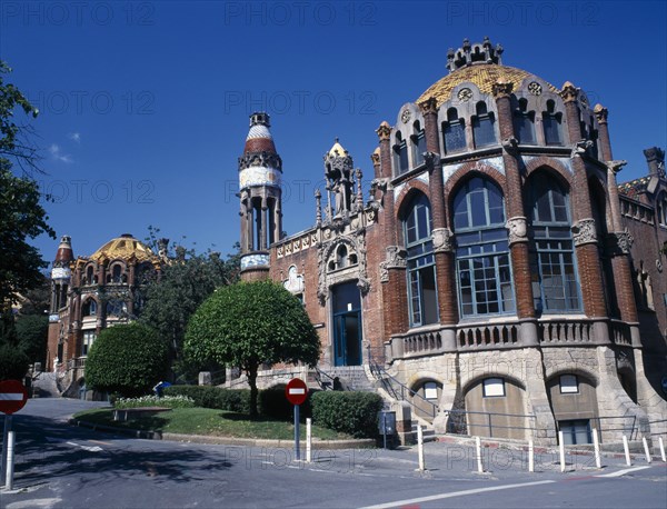 SPAIN, Catalonia, Barcelona, Hospital de Sant Pau designed by Domenech I Montaner.  Ornate facade with arched windows and domed rooftops.