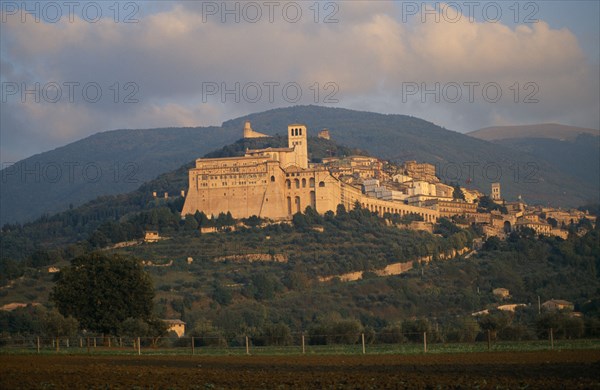ITALY, Umbria, Assisi, View of the Basilica di San Francesco and Assisi on hillside with hills behind.