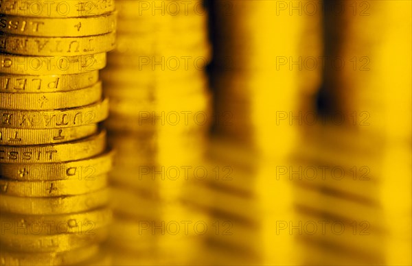 BUSINESS, Finance, Currency, Close view of piled English pound coins and indistinct reflection.