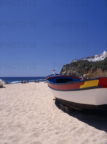 PORTUGAL, Algarve, Carvoeiro, Colourful fishing boat on the beach