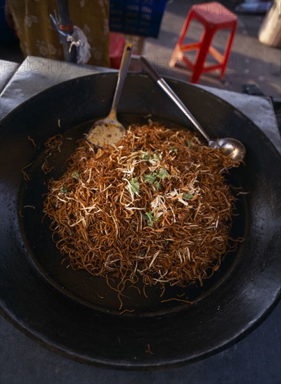 MALAYSIA, Kedah, Langkawi, A wok full of mee goreng a traditional spicey noodle dish on a stall at the Night Market in Cenang