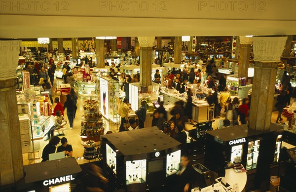 USA, New York State, New York, Macy’s department store interior.  View over busy shop floor selling cosmetics.