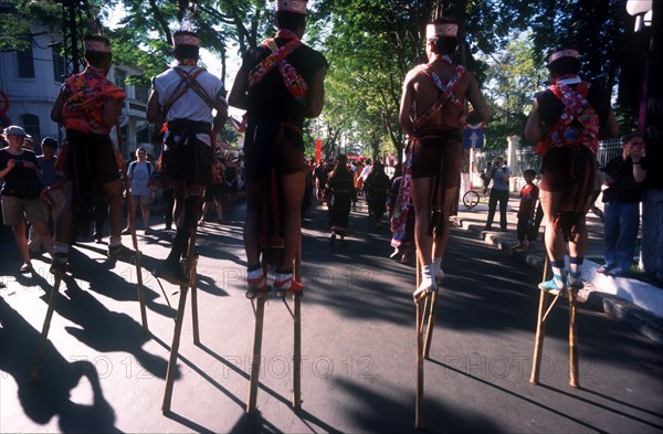 VIETNAM, Ho Chi Minh City, Line of stilt walkers at the 25th Anniversary Parade for the liberation of Saigon.
