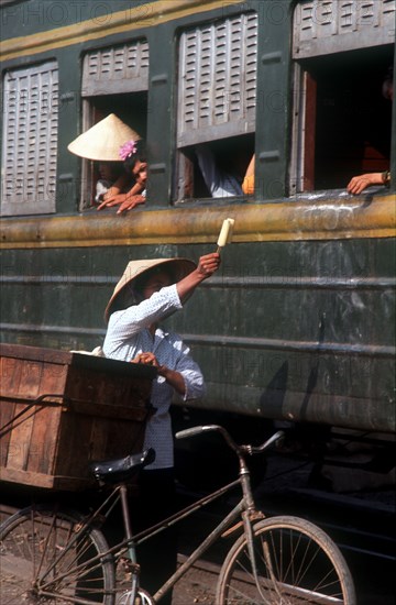 VIETNAM, Lang Son Province, Lang Son, Ice cream seller with bicycle beside train.