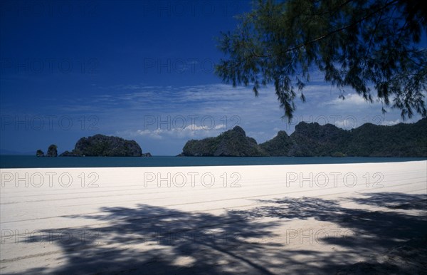 MALAYSIA, Kedah, Langkawi, Pantai Rhu beach looking out to the offshore islands from beneath casuarina trees