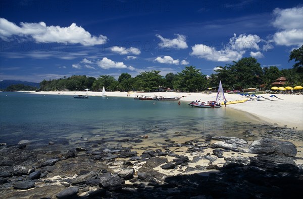 MALAYSIA, Kedah, Langkawi, Pantai Tengah beach at the south end by The Lanai hotel with tourist boats at the water’s edge