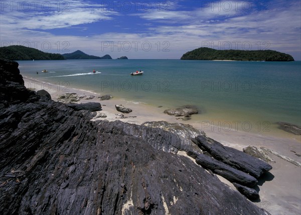 MALAYSIA, Kedah, Langkawi, Pantai Tengah beach looking out to sea towards Pulau Tepor island with jet skiers and speedboats offshore
