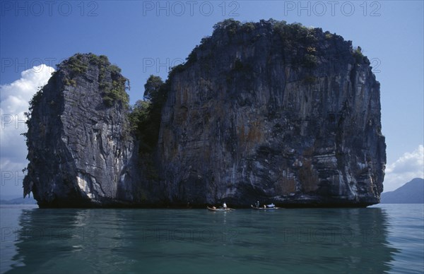 MALAYSIA, Kedah, Langkawi, Fishermen in boats beside one of the many small islands off the south coast of the main island