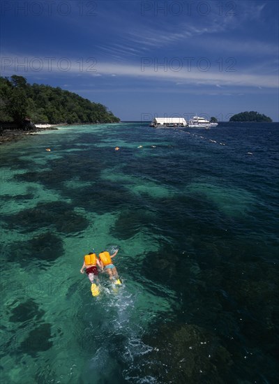 MALAYSIA, Kedah, Langkawi, Pulau Paya marine national park with two tourists snorkling above the coral reef