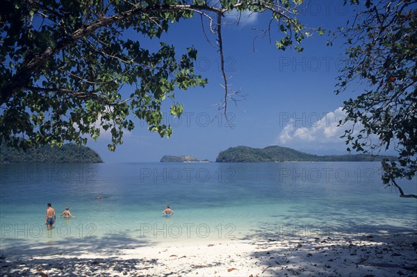 MALAYSIA, Kedah, Langkawi, Pulau Singa Besar wildlife reserve island with tourists swimming in the clear water with offshore islands