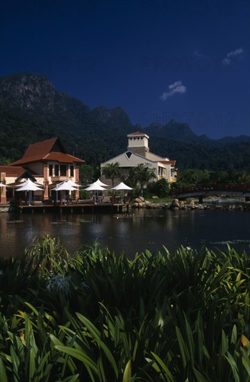 MALAYSIA, Kedah, Langkawi, Oriental Village shopping complex at Burau Bay set around an artificial lake with Gunung Mat Cincang behind