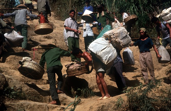 VIETNAM, Work, Smuggling on the border with China.  Porters carrying baskets of goods up a steep hillside.