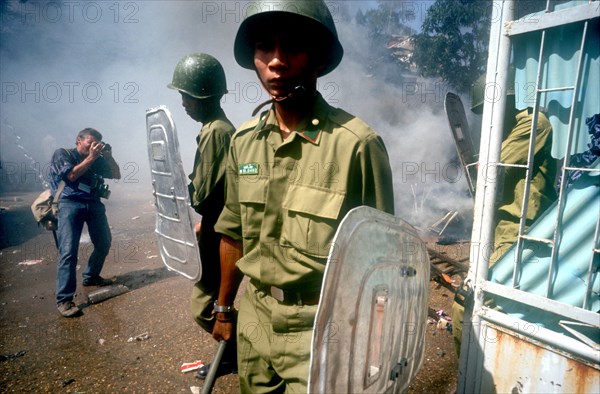 CAMBODIA, Phnom Pehn, Anti Khmer Rouge demonstration outside their city headquarters.  Soldiers with riot shields and press photographer.