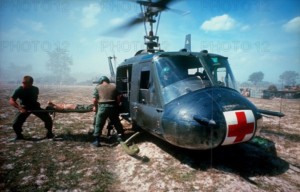 VIETNAM, Ba Cat, "Dust off operation, wounded soldier on a stretcher being lifted into helicopter ambulance. Cedar Falls"