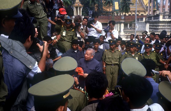 CAMBODIA, Phnom Pehn, "Sihanouk surrounded by crowds, journalists and troops at the Silver Pagoda."