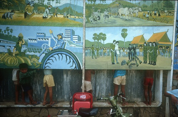 CAMBODIA, Phnom Pehn, Anti Khmer Rouge posters with line of children behind so only their legs can be seen.