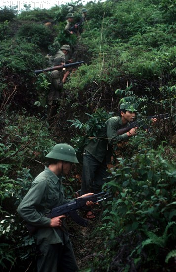 VIETNAM, Cao Bang Province, Pac Bo, Soldiers on a training exercise.  View up hillside along advancing line and dense undergrowth.