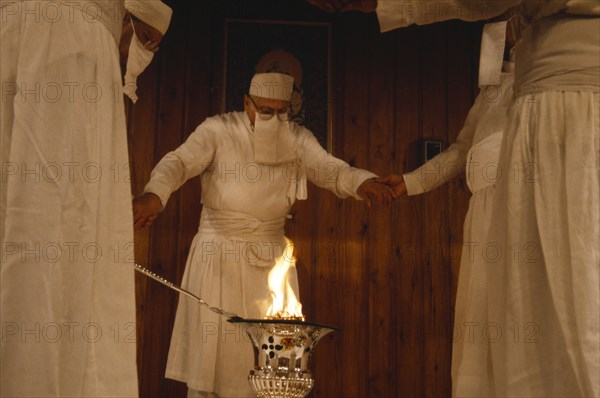 SOCIETY, Religion, Zoroastrian, Parsis encircling fire in a temple.  Flames burn eternally in their fire temples and are worshiped as a symbol of their god Ahura Mazda.