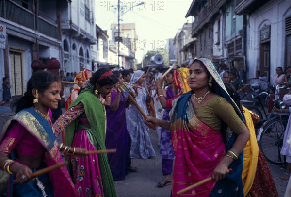 INDIA, Gujarat, Bhavnagar, Hindu wedding with women doing a traditional dance with sticks in the street