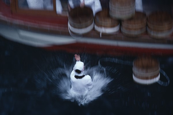 JAPAN, Honshu, Toba, Traditional Mikimoto pearl diver jumping from a boat into the water