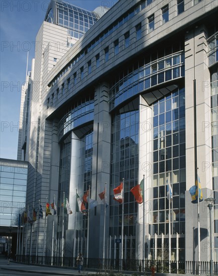 BELGIUM, Brabant, Brussels, "The European Parliament Building, modern exterior with line of flagpoles flying European flags."
