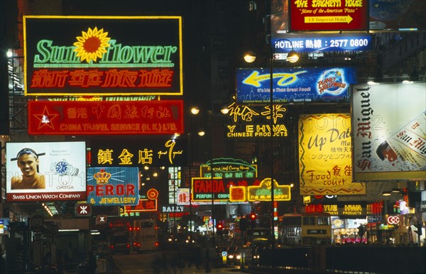 HONG KONG, Markets, Streets, Busy street with traffic and pedestrians with neon signs and advertising illuminated at night.