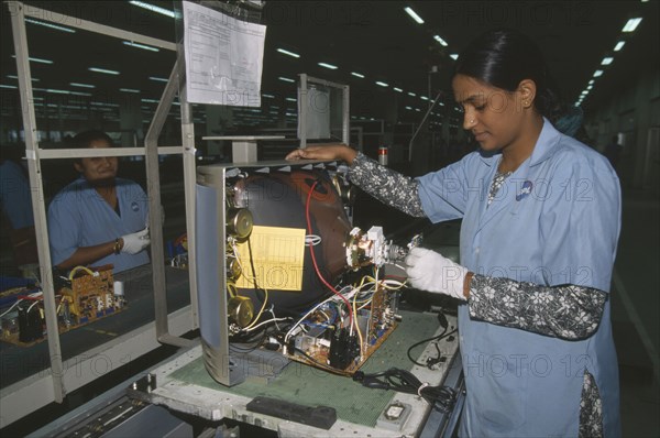 INDIA, Karnataka, Bangalore, Woman in factory making electrical components for televisions.