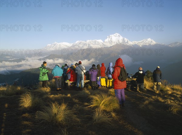 NEPAL, Annapurna Region, Poon Hill, Trekkers gathered to watch the sunrise over the Annapurna mountain range.