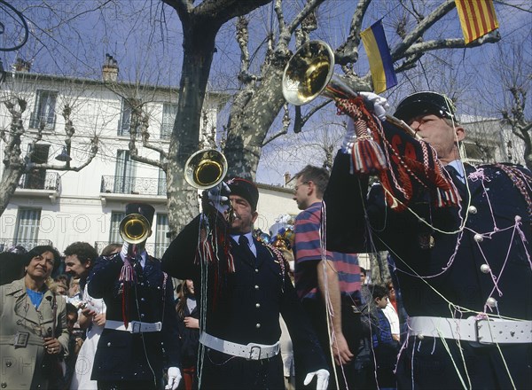 FRANCE, Cote d’Azur, Alpes Maritime, Gendarmes playing trumpets in a square in Vence during  the Easter procession of The Battle of The Flowers