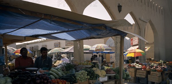 OMAN, Muscat, Mutrah produce market.  Covered stalls beside arched entrance with displays of fruit and vegetables.
