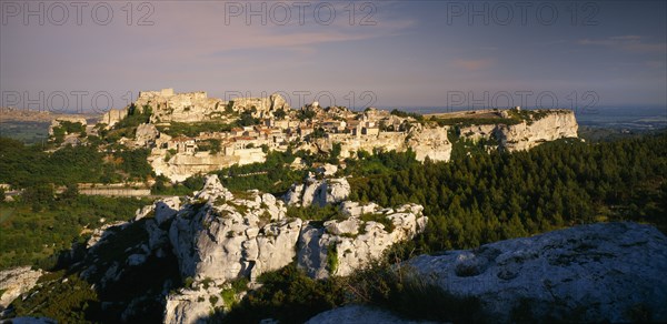 FRANCE, Provence-Cote d’Azur, Les Baux de Provence, View over rocky outcrop towards fortified hill town.  Bouches du Rhone.