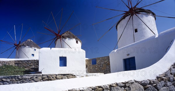 GREECE, Cyclades Islands, Mykonos, Three white painted windmills against blue sky.