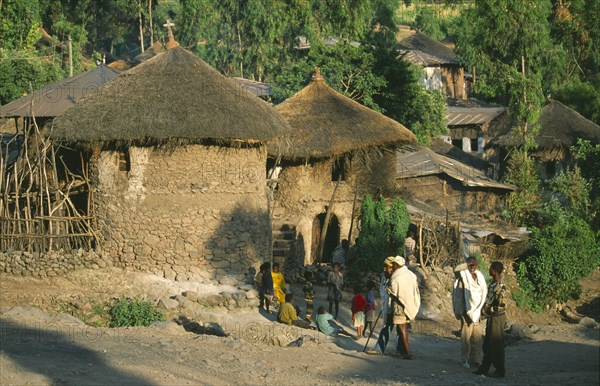 ETHIOPIA, Wolo Province, Lalibela, "Two storey, circular stone buildings with thatched rooftops, unique to the area.  Villagers and children on road outside."