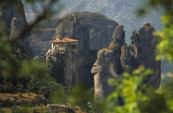 GREECE, Thessalia, Meteora, "Monastery  amongst eroded rock pinnacles, seen through tree branches. "